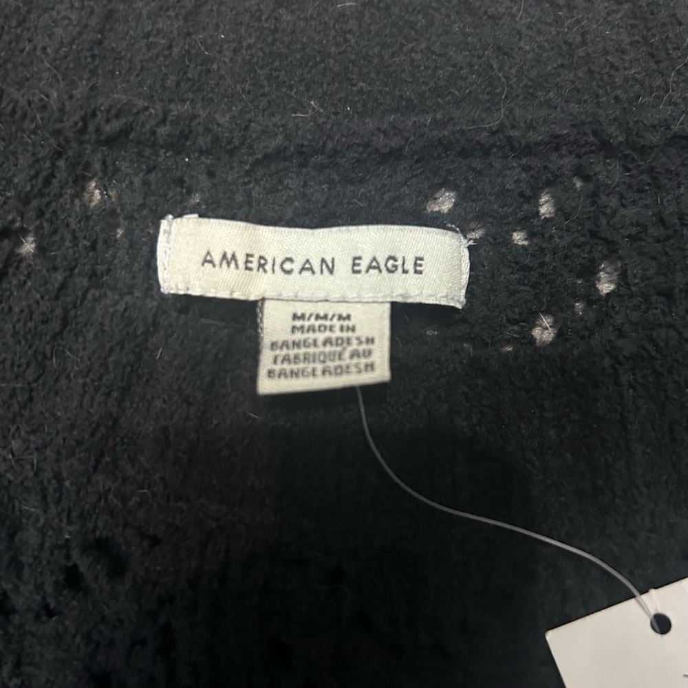 Somewhat cropped black sweater with intentional holes, never worn with tags.